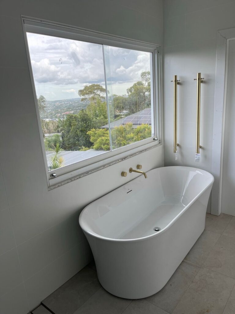 Renovated bathroom with freestanding bath, brushed brass tapware and district views at Beacon Hill