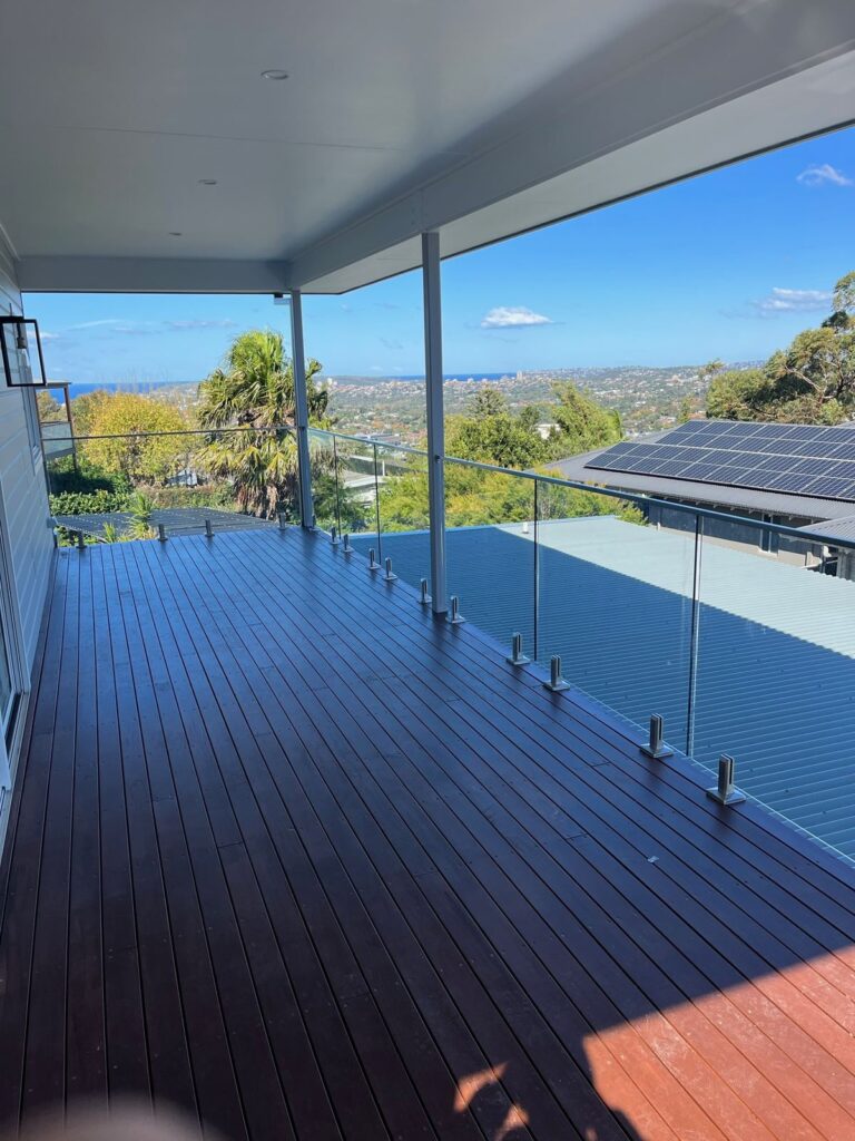 Covered timber deck with frameless glass balustrade and district views at Beacon Hill